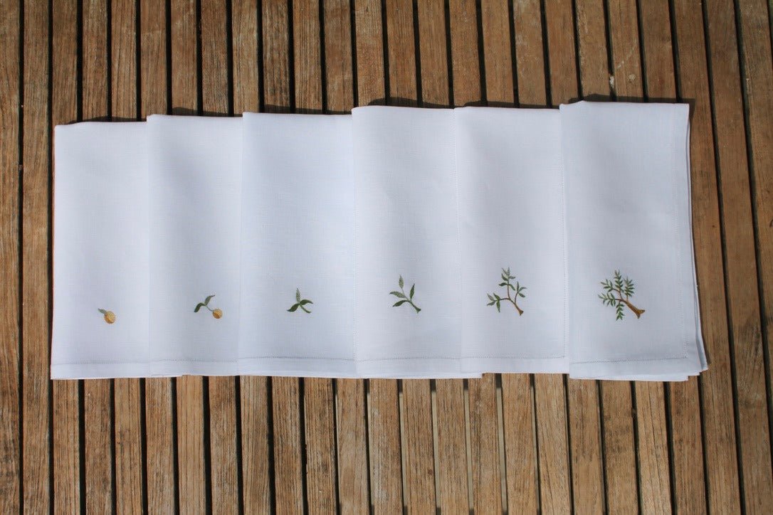 White fabric with embroidered designs on a wooden surface